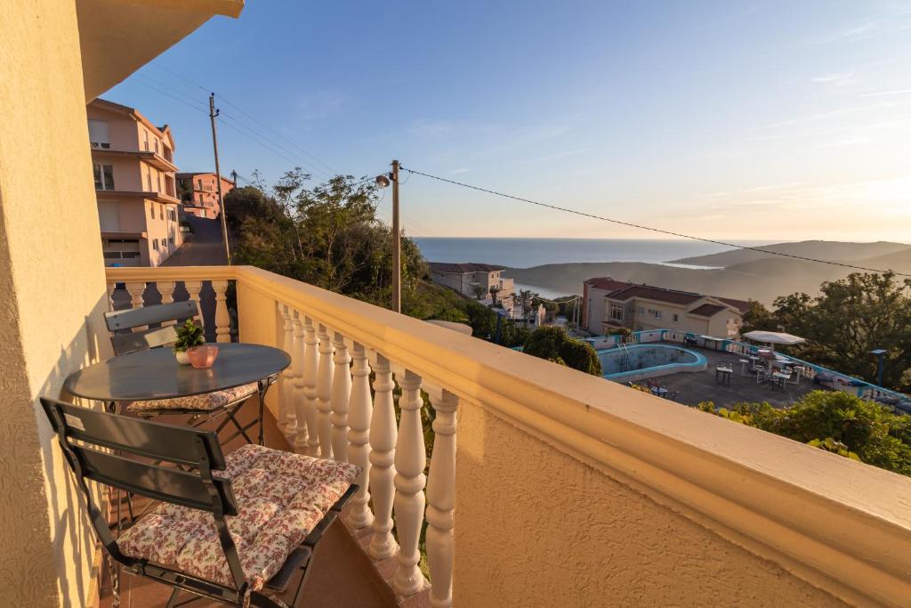a table and chair on a balcony with a view at Room Dragičević with Garage in Budva