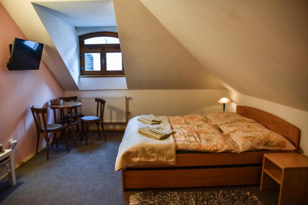 1 dormitorio con cama y mesa pequeña en Penzion Čas, en Český Rudolec