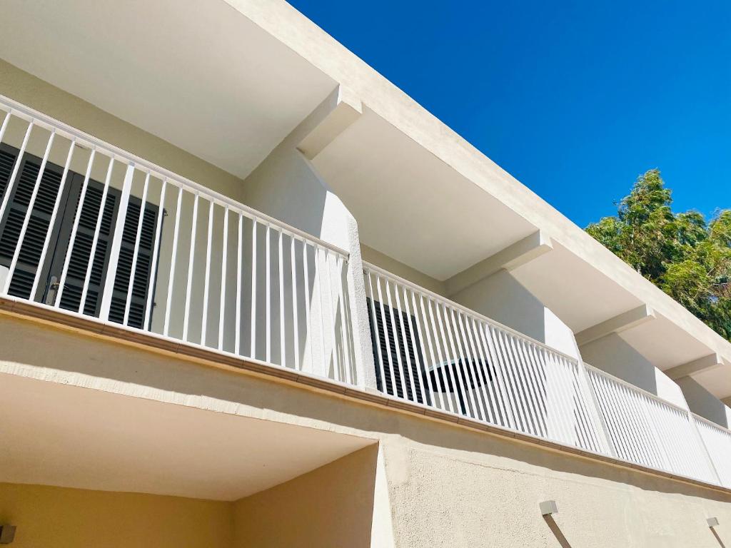a balcony with white railings on a building at Hostal Villa Senese in Paguera
