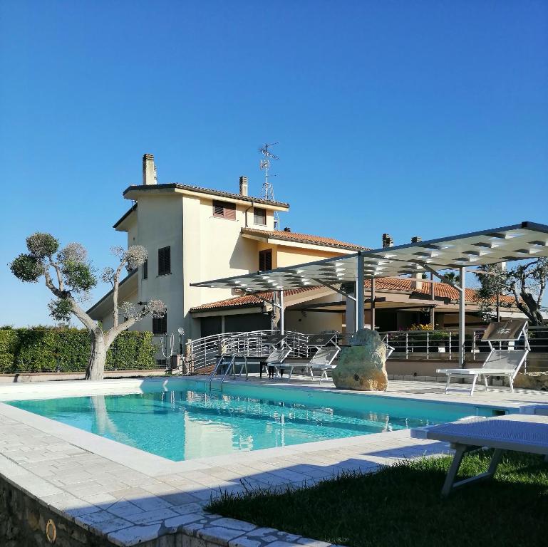 a swimming pool with chairs and a building at Bed & Breakfast Giardini Di Marzo in Lecce