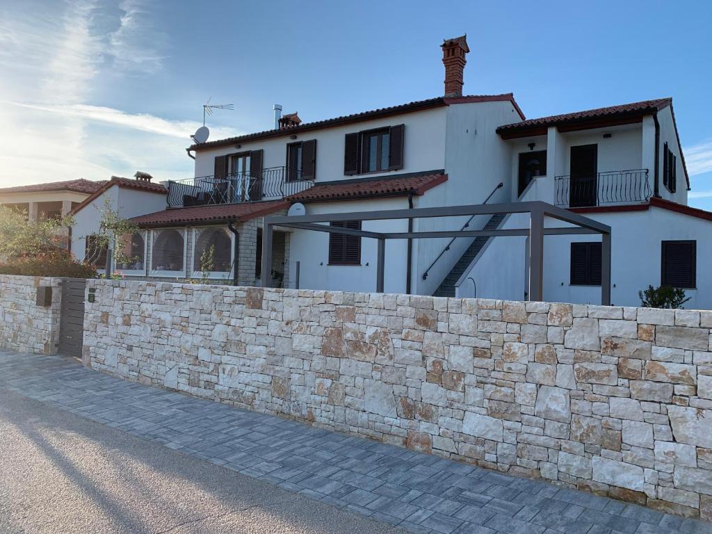 uma parede de pedra em frente a uma casa em Apartments & Room Piutti em Bale