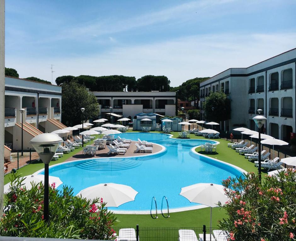 a large swimming pool with umbrellas and chairs at Michelangelo Holiday & Family Resort in Lido di Spina