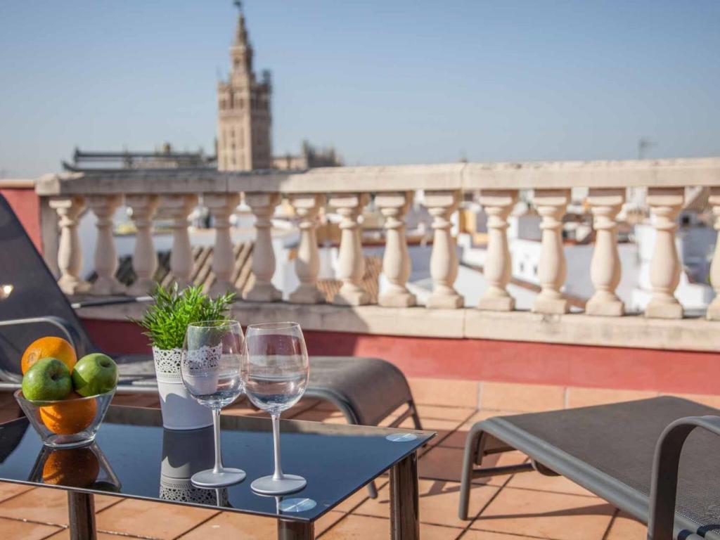 einen Tisch mit zwei Weingläsern auf dem Balkon in der Unterkunft Federico rubio in Sevilla