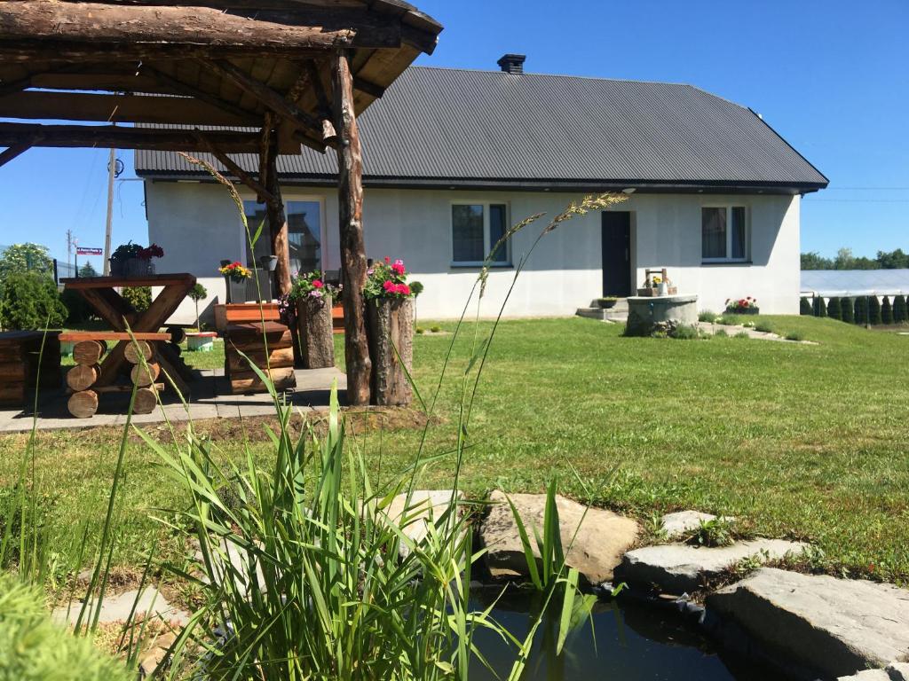 ein Haus mit einem Teich im Hof in der Unterkunft Pokoje Amelia in Zator