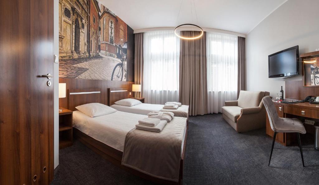 Pokój hotelowy z łóżkiem i biurkiem w obiekcie Hotel Downtown Kraków w Krakowie