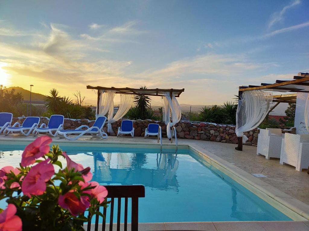 a swimming pool with chairs and a gazebo at Sa Corti De Sa Perda Piscinas in Piscinas