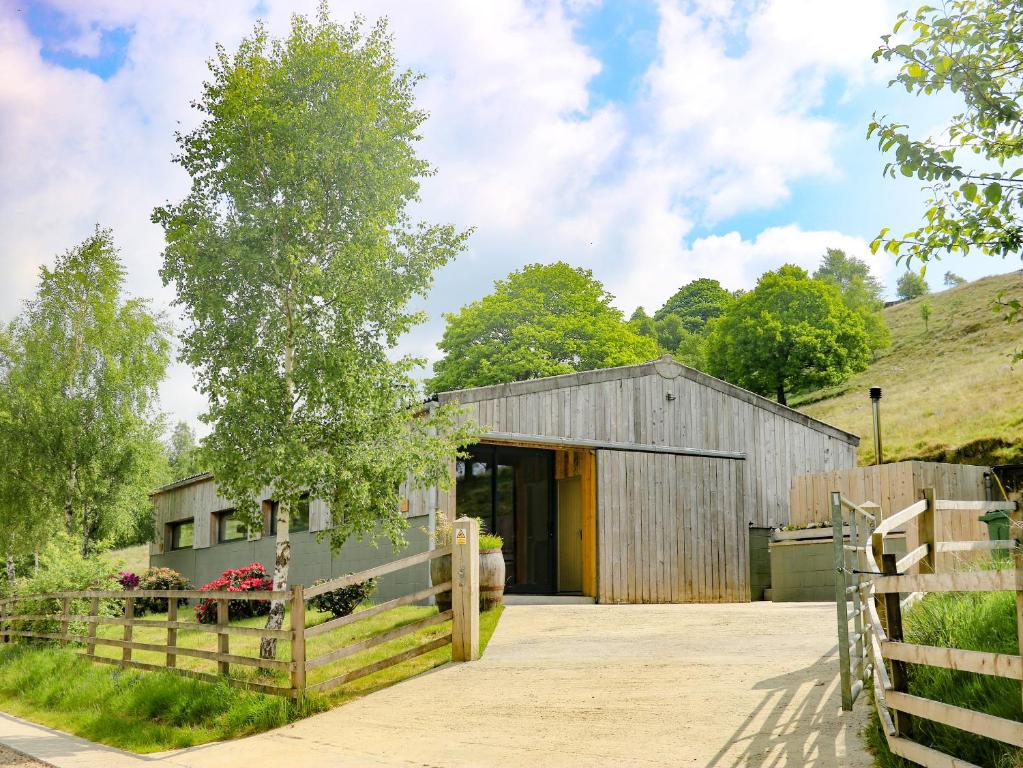 a barn with a fence in front of it at Ash Bank, Jacobs Wood in Keighley