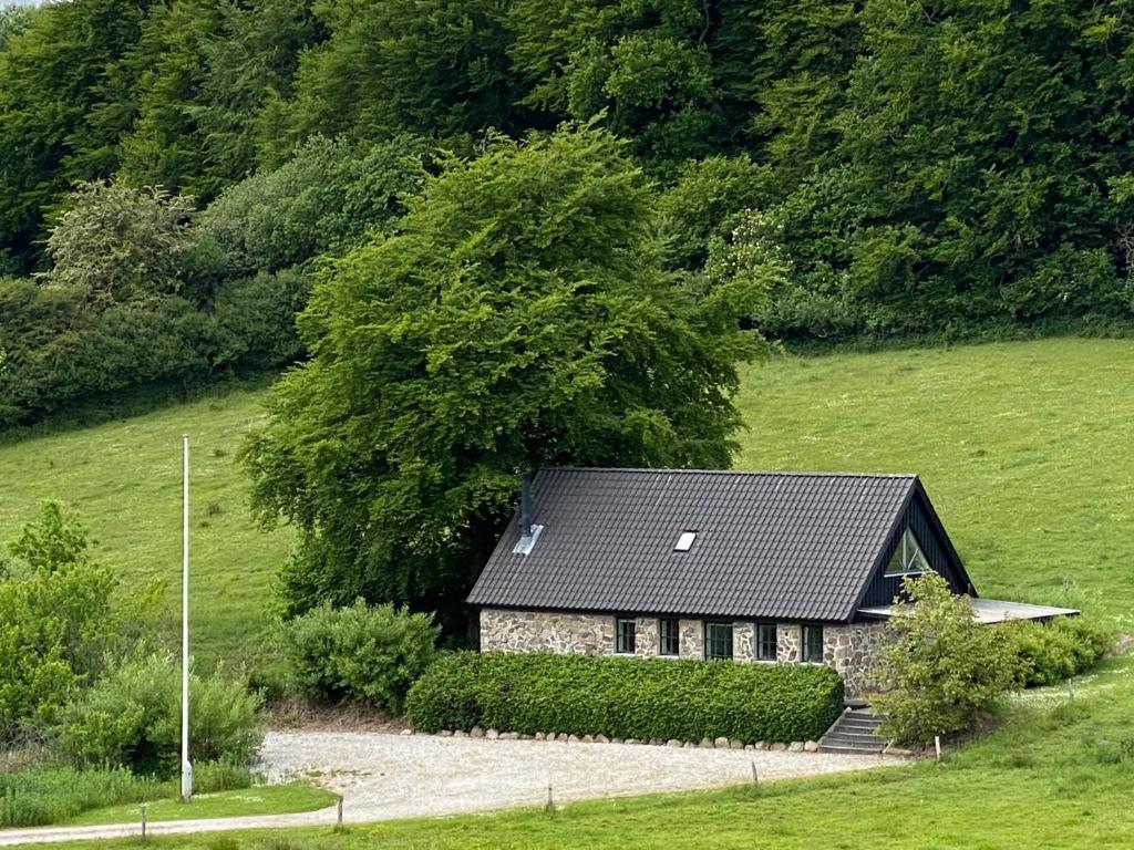 una pequeña casa en medio de un campo en Stenhuset i Pilbrodalen, en Skanderborg