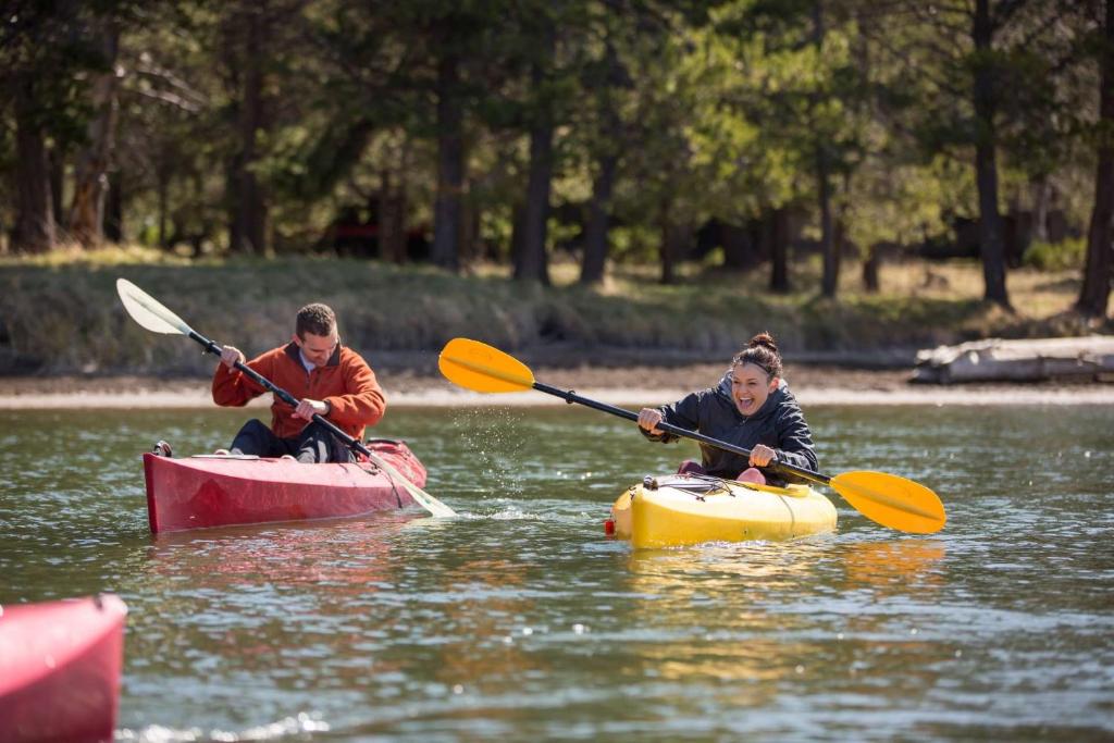 dos personas están haciendo kayak en un río en el agua en Drake Cottage 307, en Bend