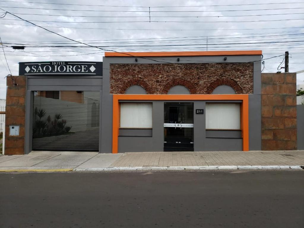 a building with an orange trim on a street at Hotel São Jorge in Alegrete