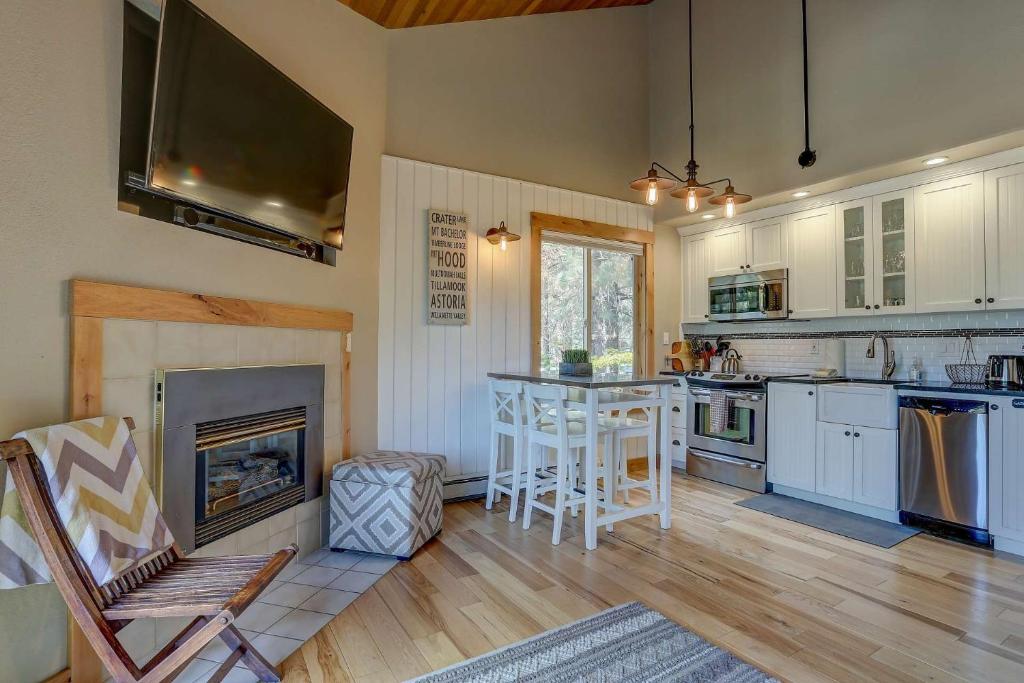 a kitchen with a fireplace and a table and chairs at Gateway to Mt Bachelor in Bend