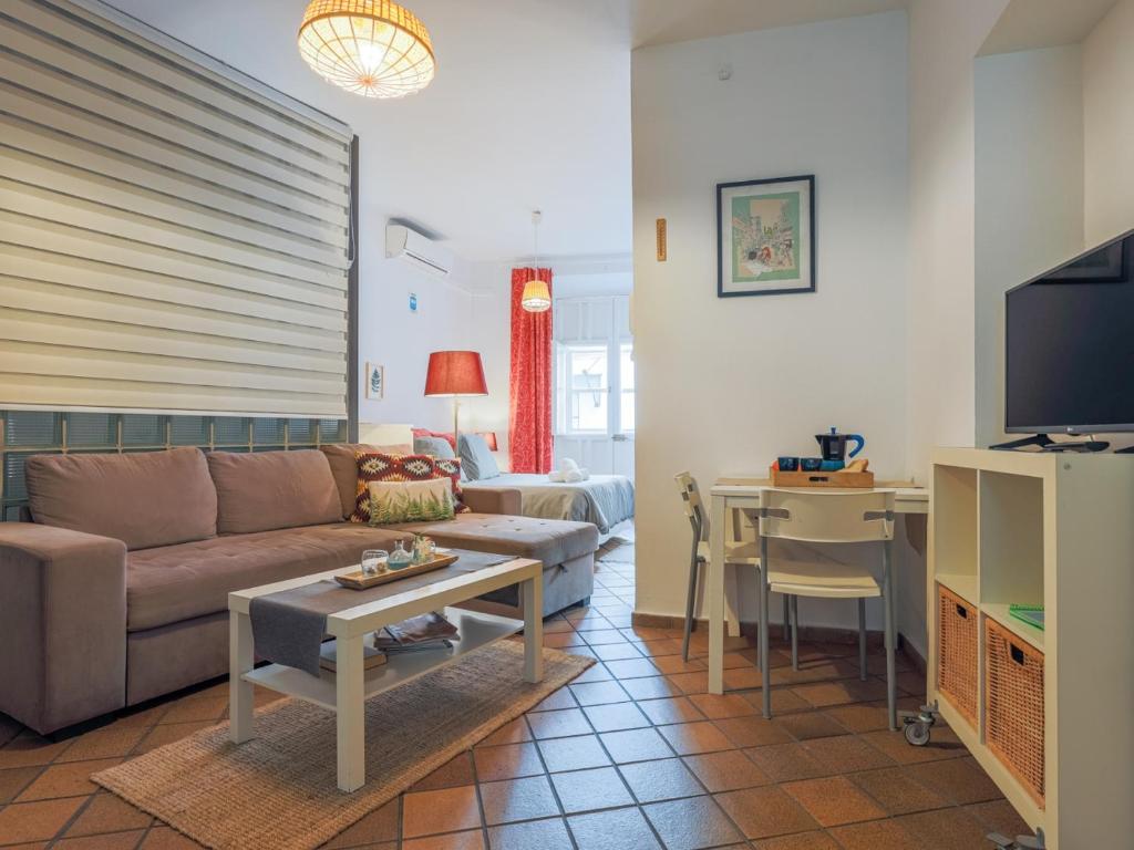 een woonkamer met een bank en een tafel bij San esteban medio in Sevilla