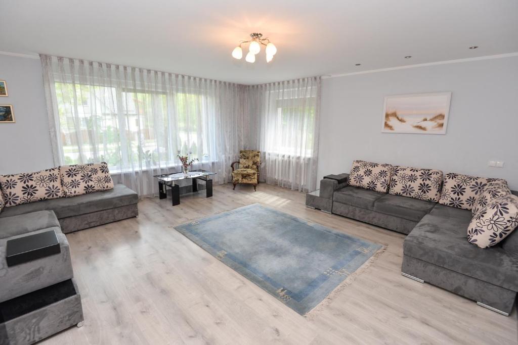 Sala de estar con 2 sofás y mesa en Poilsis prie Dineikos parko, en Druskininkai