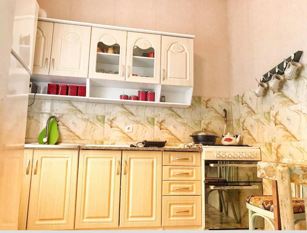 a kitchen with white cabinets and a counter top at Shmagdas House Sighnaghi შმაგდას სახლი სიღნაღში in Sighnaghi