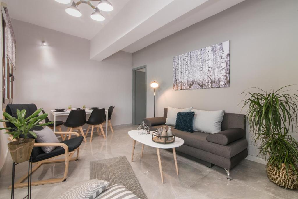 a living room with a couch and a table and chairs at Valentine's Modern Apartment in Zakynthos Town