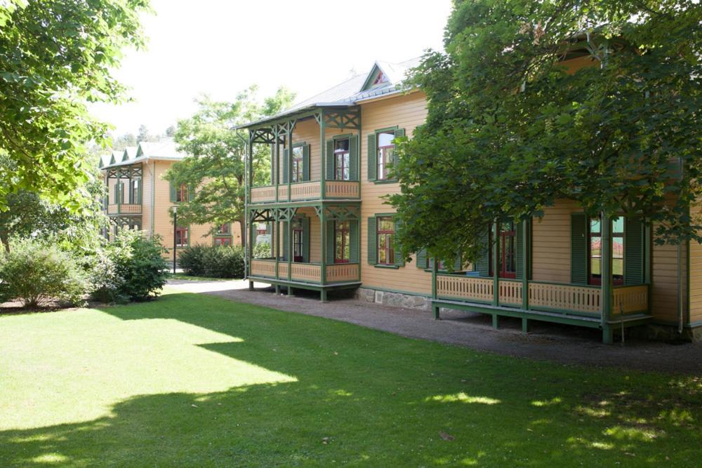 una casa con dos bancos frente a un patio en Café Mandeltårtan B&B VillaFloraViola, en Ronneby