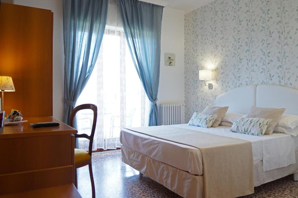 a bedroom with a bed and a window with blue curtains at Villa Susy Relais in Sant'Agnello