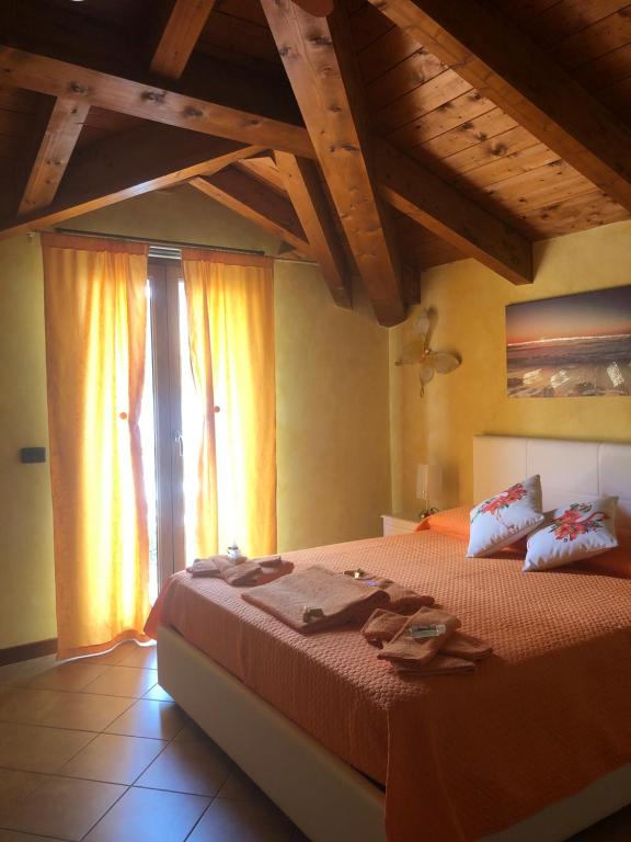 - une chambre avec un grand lit et des serviettes dans l'établissement B&B Fior di Loto, à Ceriale