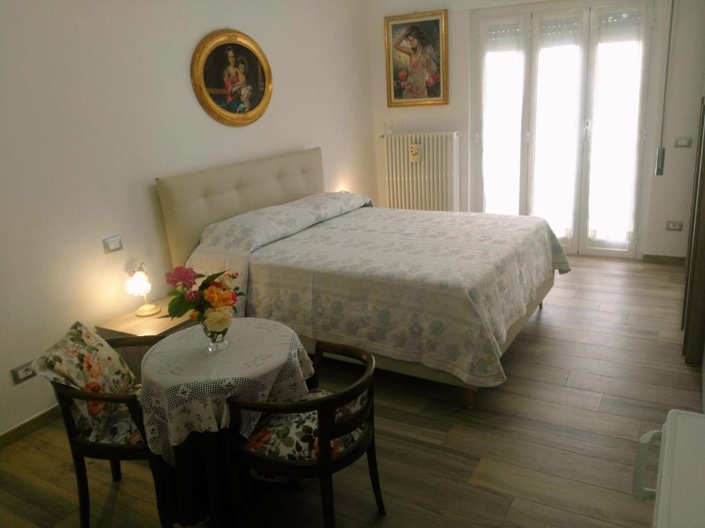 1 dormitorio con 1 cama, mesa y sillas en B&B Sweet Dreams en Diano Marina