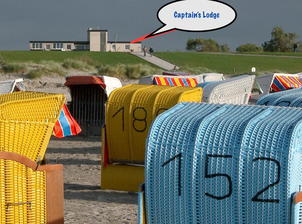 a row of colorful baskets sitting on the beach at Apartment CAPTAIN'S LODGE in Norddeich