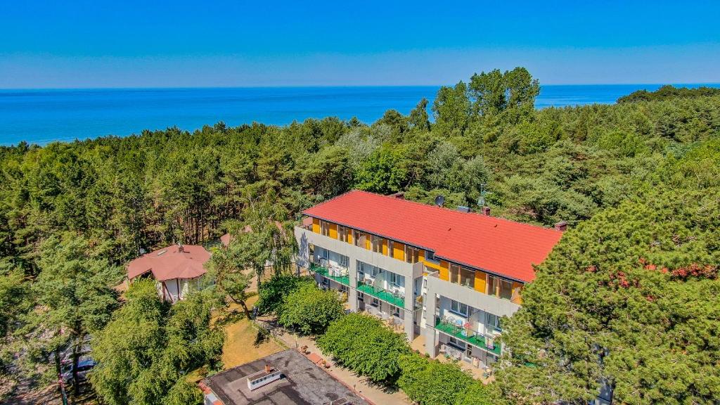 une vue de tête d'un bâtiment avec un toit rouge dans l'établissement Ameba, à Mielno