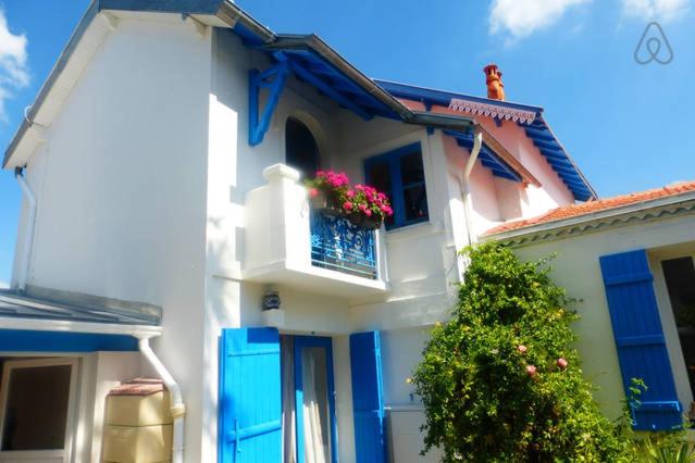 ein weißes Haus mit blauen Türen und einem Fenster mit Blumen in der Unterkunft Les Volets Bleus in Pornic