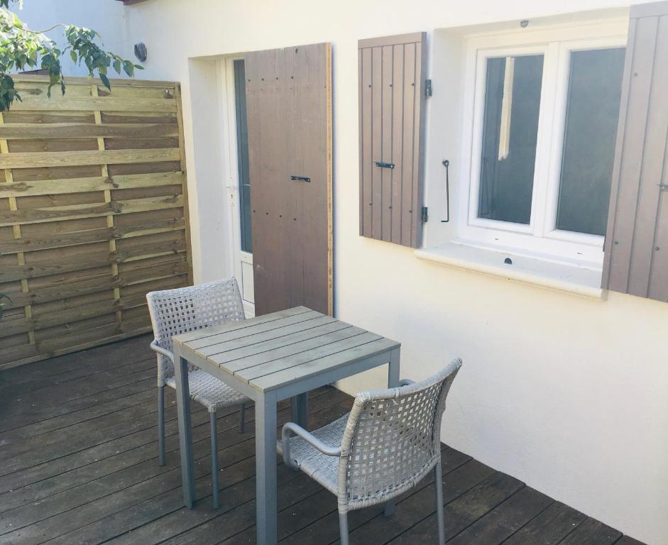 einen Tisch und Stühle auf einer Terrasse mit einem Fenster in der Unterkunft Residence Cabiscol in Beaucaire