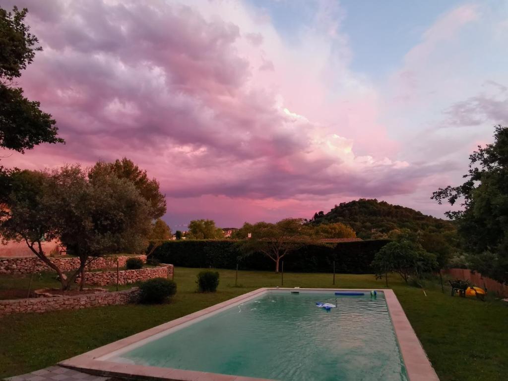a swimming pool in a yard with a cloudy sky at mas cantarello in Rognes