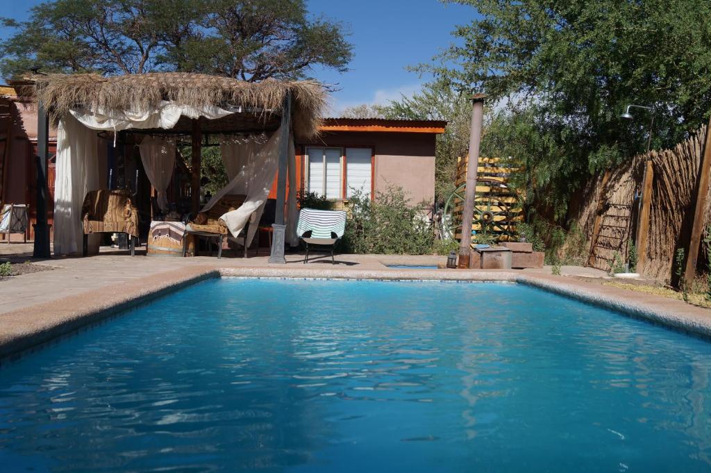 a swimming pool in front of a house at Atacama Lodge Rukazen Spa Rústico in San Pedro de Atacama