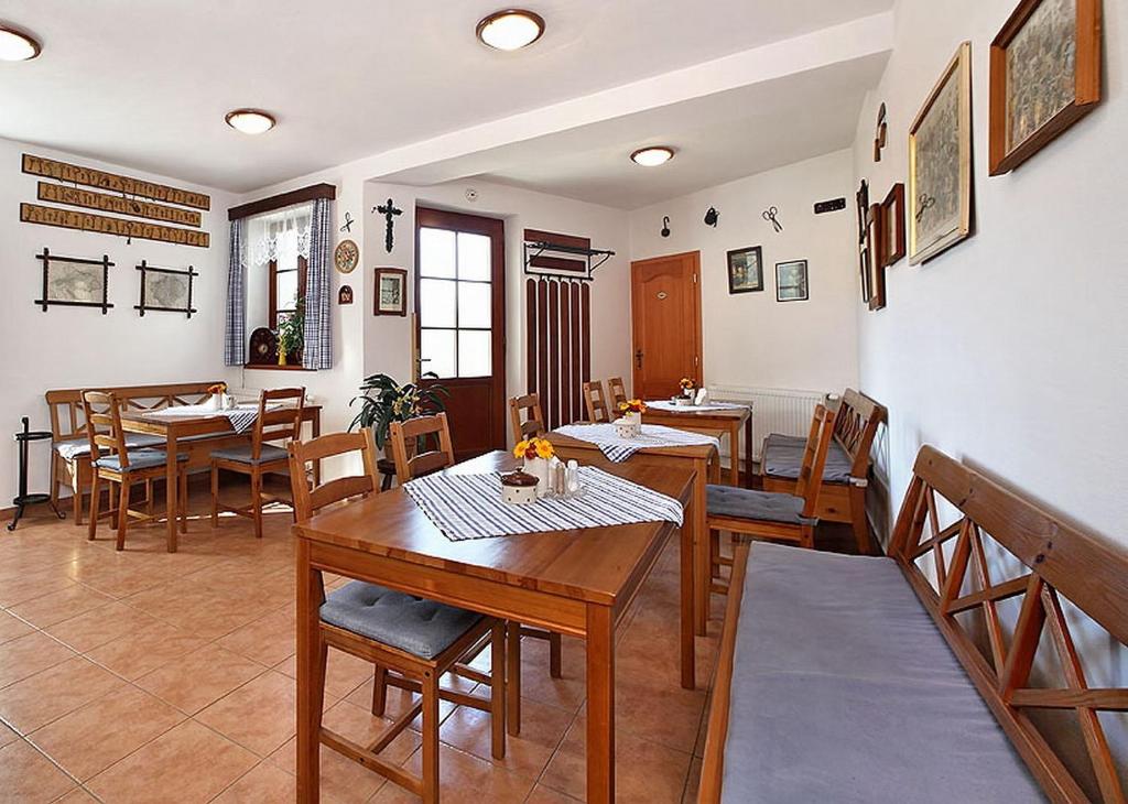 Penzion Kříž في تشيسكي كروملوف: غرفة طعام مع طاولات وكراسي خشبية