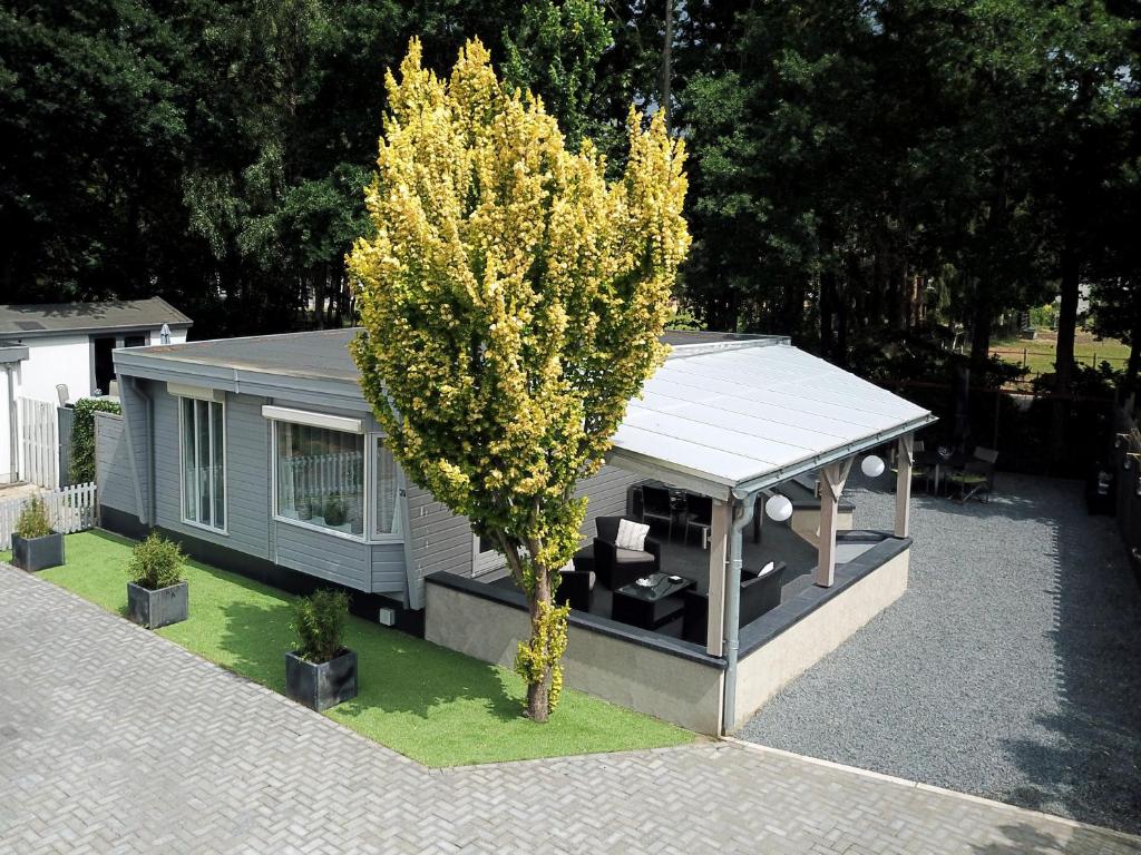 ein kleines Haus mit einem Baum davor in der Unterkunft Chalet nr 30 in Putten in Putten