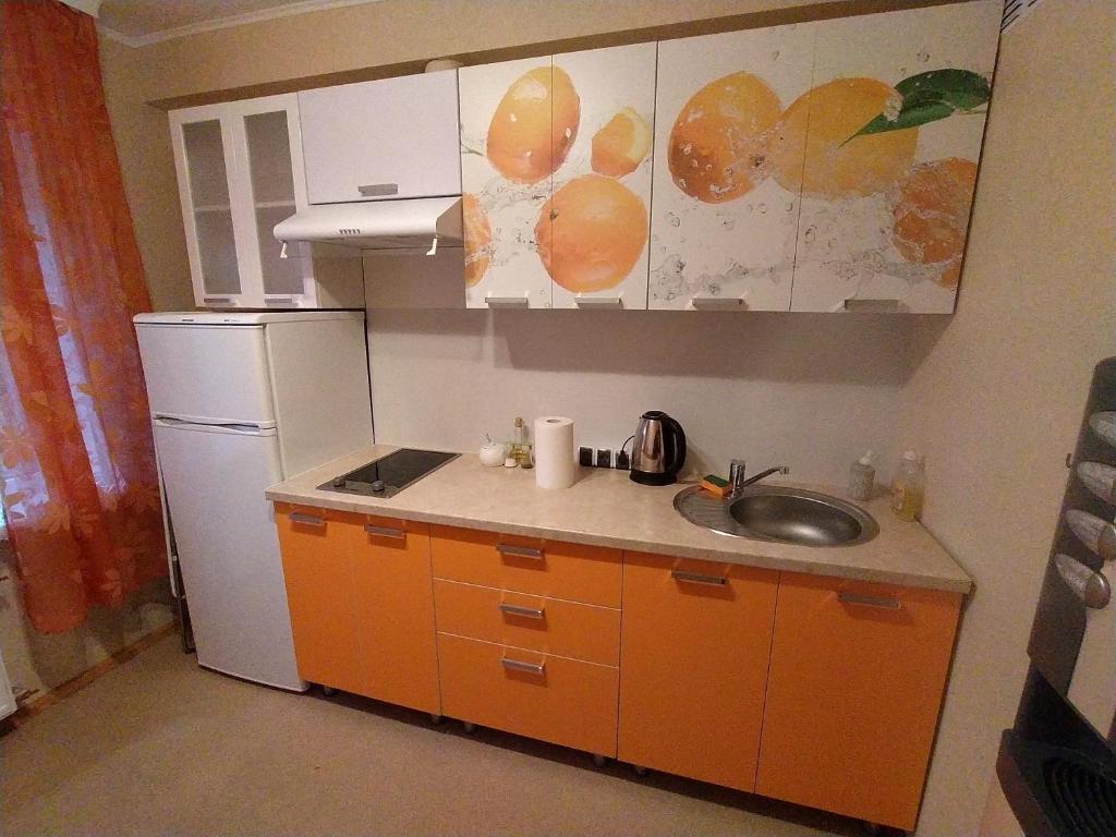 a small kitchen with a sink and a refrigerator at Rojas street apartments in Liepāja