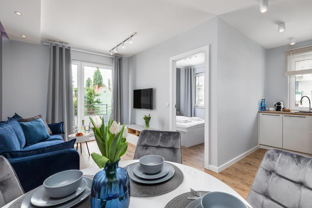 a living room with a blue vase on a table at PREMIUM Apartments New Town Private Parking Included in Szczecin