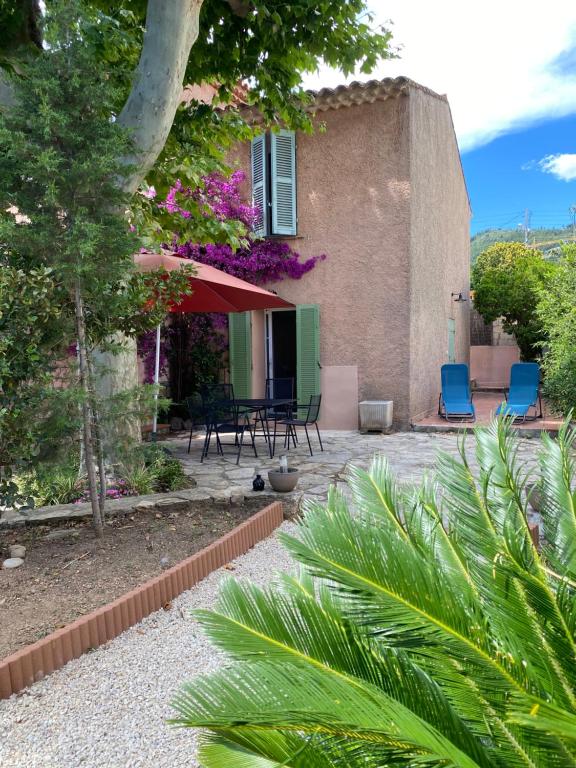 um jardim com cadeiras e uma casa com um edifício em Petite maison au calme avec jardin clim et parking em Toulon