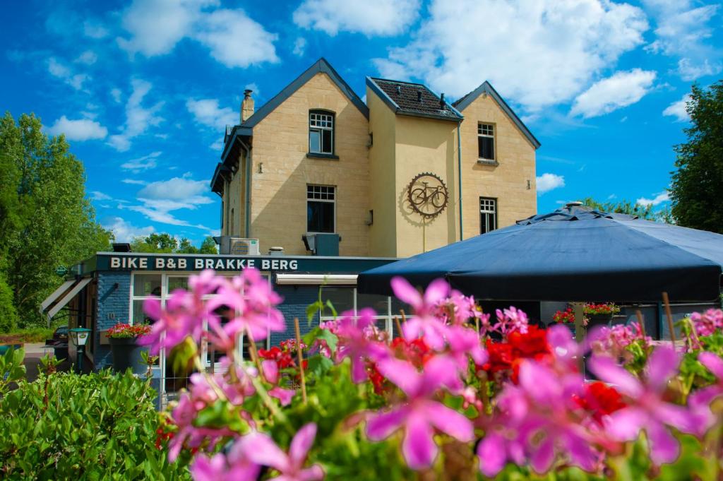 Um edifício com flores cor-de-rosa à frente. em B&B Brakke Berg em Berg en Terblijt