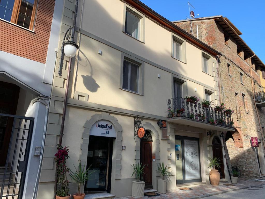 een wit gebouw met planten op een straat bij L'Arco B&B di Charme in Passignano sul Trasimeno