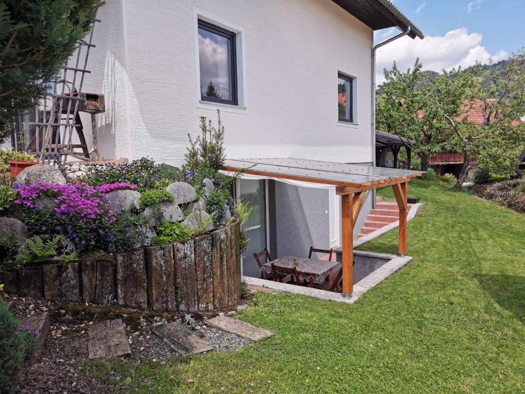 ein Haus mit einem Holztisch im Hof in der Unterkunft Apartma Slivnik in Spodnje Gorje