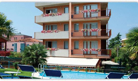 - un bâtiment avec une piscine et des chaises en face dans l'établissement Hotel St. Antony, à Bardolino