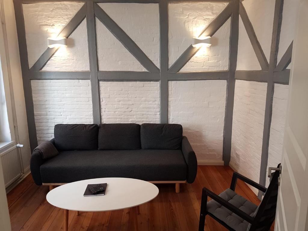 ein Wohnzimmer mit einem Sofa und einem Tisch in der Unterkunft Altstadtquartier in Flensburg