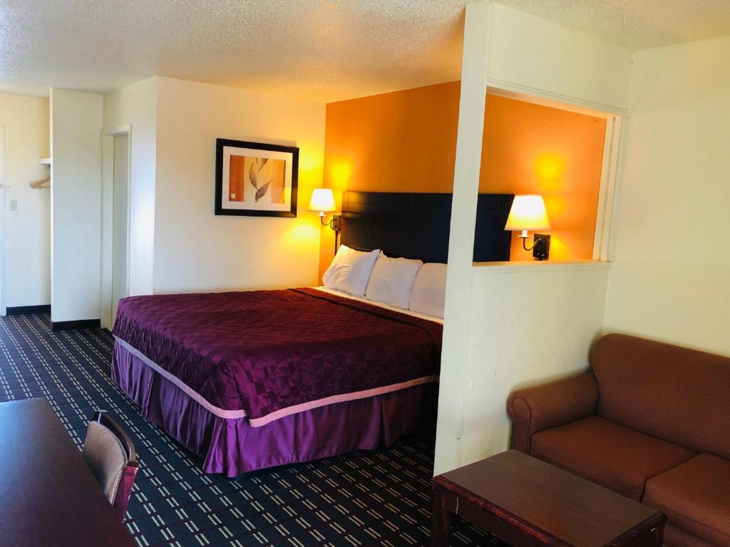 Habitación de hotel con cama y sofá en Executive Inn & Suites Prescott, en Prescott