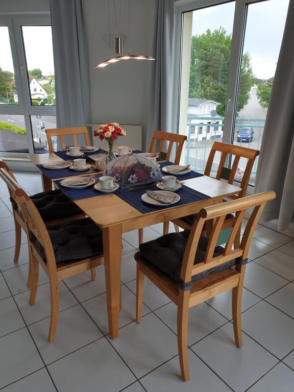 a wooden dining room table with four chairs and a table at Ferienwohnung Sonnenblick in Zempin