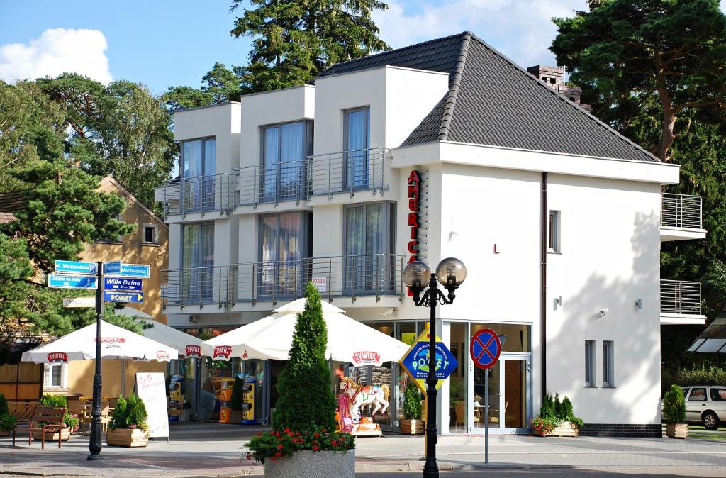 a white building with a balcony on a street at Americano in Niechorze