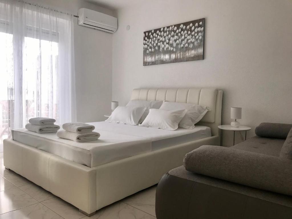 ein weißes Schlafzimmer mit einem großen Bett und einer Couch in der Unterkunft Jurkas in Trogir