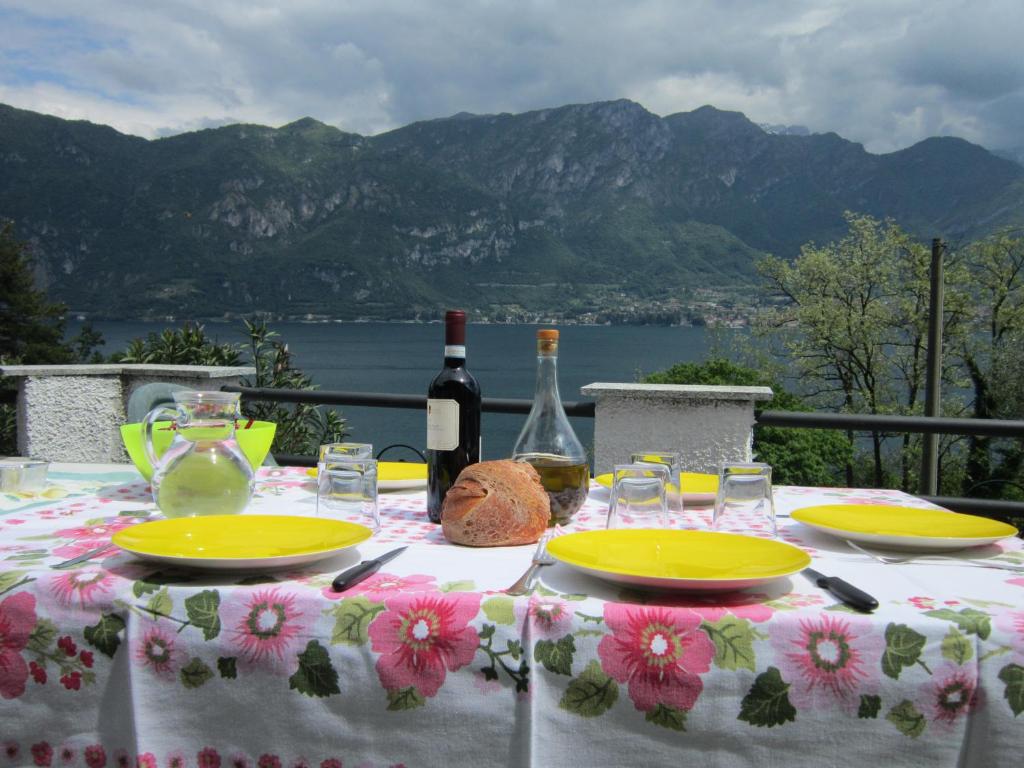 un tavolo con due piatti e due bottiglie di vino di casa indipendente "IL SOLE DELLE GRIGNE" a Bellagio