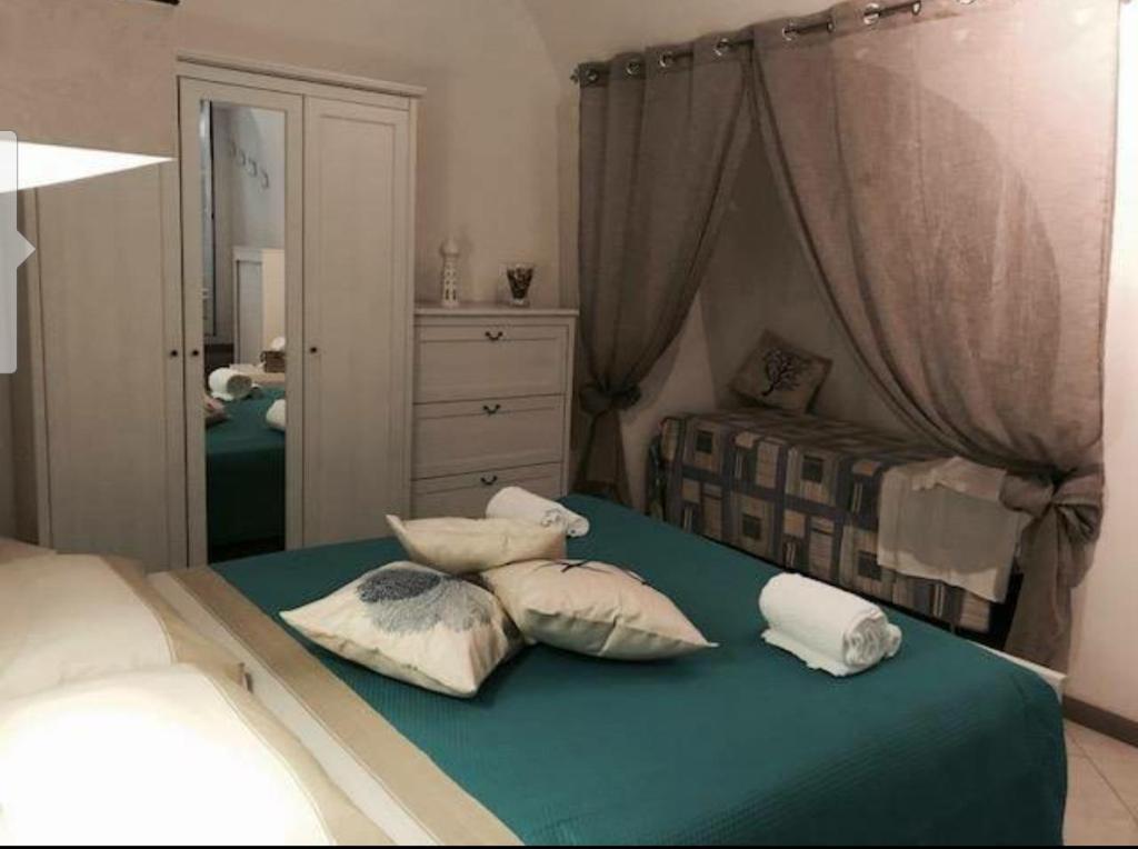 una camera da letto con un letto con cuscini sopra di Casa Kale' a Polignano a Mare