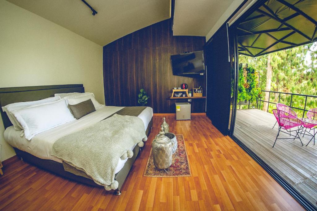 a bedroom with a bed and a deck with a patio at Hotel Mumu Guatapé in Guatapé