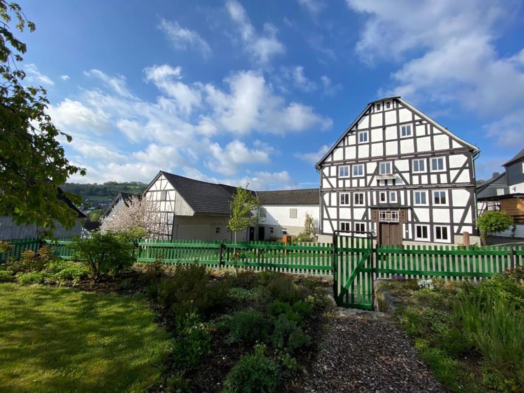 a large white house with a green fence at Hof Hallenberg in Hallenberg