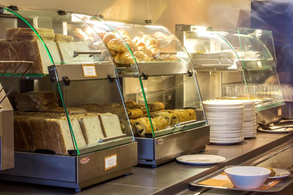 a kitchen with a counter with pastries and bread at Holiday Inn Express London Limehouse, an IHG Hotel in London