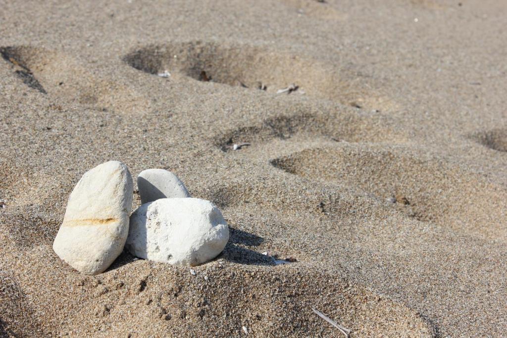 a pair of rocks in the sand on a beach at Galini in Agia Irini Milos