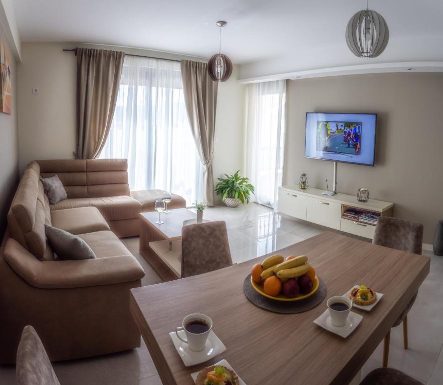 uma sala de estar com uma mesa e um sofá em Ralux apartman Tivat em Tivat
